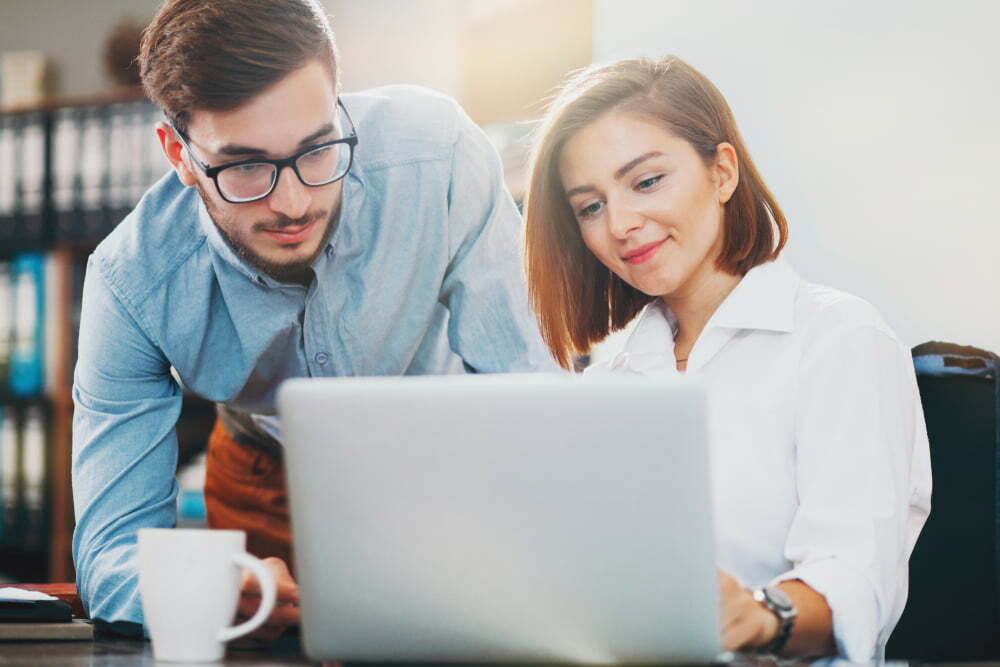 men and women working on laptop